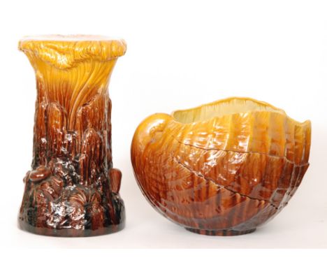 A large early 20th Century Bretby jardiniere and pedestal stand, the jardiniere formed as a conch shell glazed in tonal yello