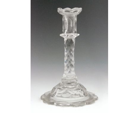 An 18th Century glass taper stick circa 1785, scaloped edge sconce above a diamond facet cut stem raised on facet dome and  s