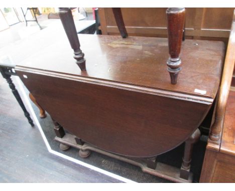 A mid oak dining table having drop flap top on bulbous pillar gate legs