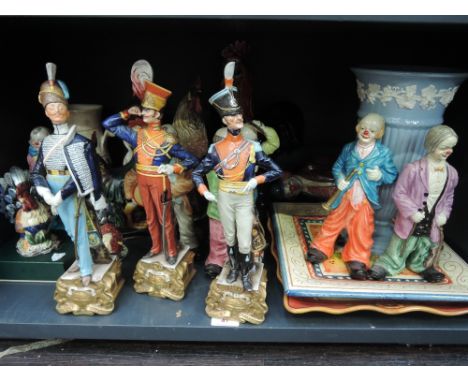 A shelf of modern continental  decorative figurines including clowns and cockerels