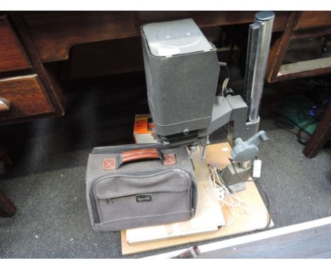 A vintage film projector on stand with cameras and accessories