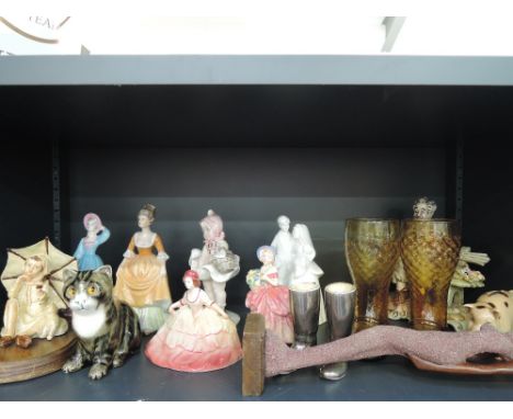 A shelf of decorative ornaments including glass boots, kittens etc