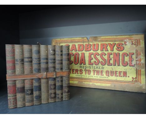 A vintage money tin modelled as a stack of books and a vintage Cadbury advertising label