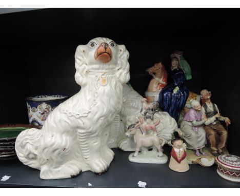 A shelf of decorative ceramics including a pair of Staffordshire fireside dogs, plaice plates etcs