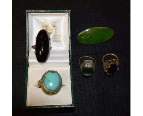 A Chinese turquoise set silver ring; jade brooch; three other rings
