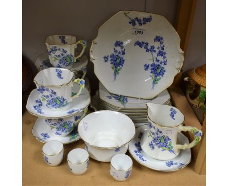 An Art Deco Royal Stafford part tea set, printed with blue flowers, angular floral handles, comprising four teacups, five sau