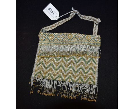 A 1920s Art Deco beadwork evening purse, geometric design, silver, green and mustard beads, fringed detail, kid leather lined