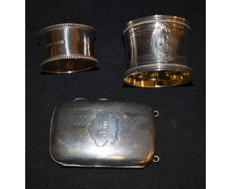 A silver rounded rectangular cigarette case, engine turned, gilt lined, Birmingham 1914; two silver napkin rings, 109g gross 