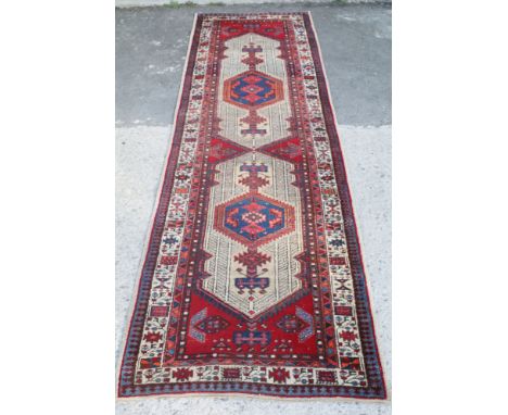 Large runner rug with geometric patterns and blue and cream border, W 96cm