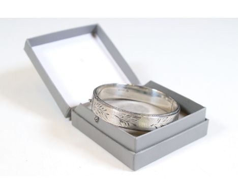 Silver hallmarked hinged bangle with safety chain, with brushed and foliate chased design
