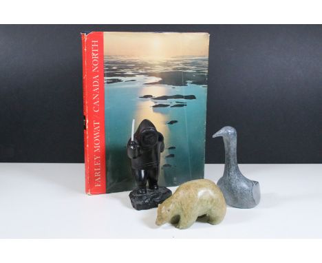 Group of three Canadian carved stone figurines to include bear, bird and fishing Inuit examples together with Canada North bo