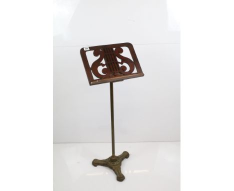 19th Century Victorian mahogany adjustable music sheet stand with carved floral scroll design on brass tripod base, measures 