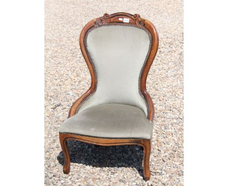 Early 20th century mahogany nursing chair with carved surround, upholstered back and seat on cabriole legs