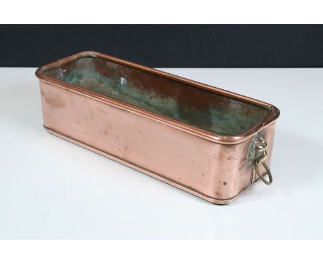 Copper planter with rolled rim and brass lion mask drop ring handles, 31cm long