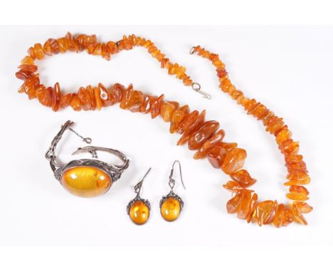 A selection of ladies amber jewellery to include a beaded amber necklace together with a bangle bracelet and earring set.