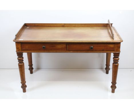 Early 20th century mahogany desk with two drawers and back and side surround to top, raised on turned legs, H 68cm, W 122cm, 