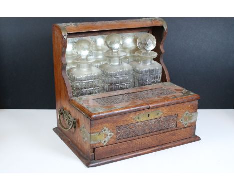 Late 19th Century Victorian oak cased three bottle tantalus with silver plate mounts, the front opening to reveal compartment