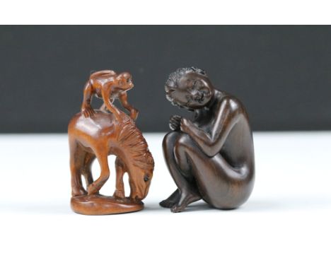 Two Japanese wooden carved netsuke of a nude female and a monkey on horse, both with character marks to base.