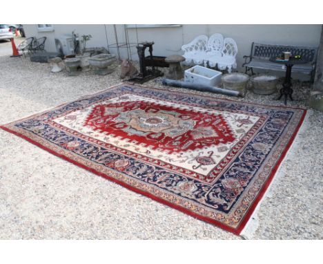 Red blue and cream ground rug with large medallion centre panel and repeat pattern border approx. 366cm x 275cm