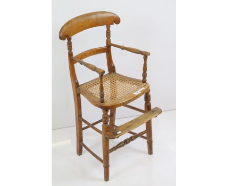 Late 19th century child's high chair with caned seat, curved top rail, foot step, turned front legs united by six stretchers,