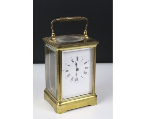 A late 19th to early 20th century brass cased carriage clock, beveled glass panels with white enamel dial.