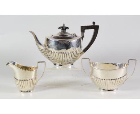 THREE PIECE SILVER TEA SET, comprising tea pot, sucrier and cream jug of half fluted oval form with engraved initials "L K". 