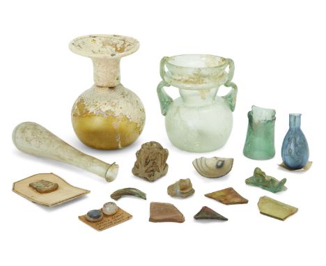 Four Roman glass vessels Circa 1st-4th Century A.D.  Two glass unguentaria, one almost clear with an old ink inscribed label 