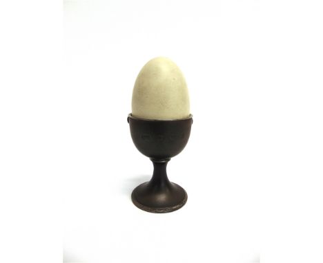 AN ANTHONY ELSON LIMITED EDITION SILVER, SILVER GILT AND ENAMEL SURPRISE EGG IN AN EGG CUP London 1980, the white enamel egg 