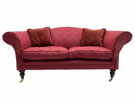 Traditional design two seat sofa, upholstered in red fabric, turned mahogany feet with brass castorsDimensions: Height:&nbsp;