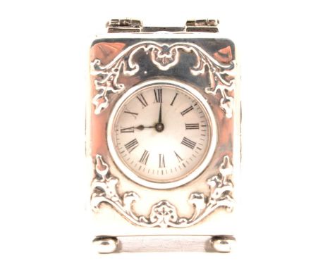 A silver boudoir clock, William Comyns &amp; Sons, London 1900, scroll and four winds decoration, French movement, on four bu