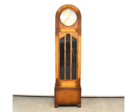 Oak longcase clock, 1930s, domed top, glazed door, block feet, twelve inch circular dial, triple weight movement striking on 