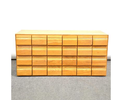 Light oak bank of twenty four filing drawers, ply lined, width 101cm, depth 42cm, height 48cm.Condition report:Tere are twent