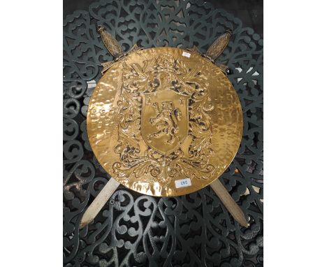 A vintage brass shield and short sword set, having raised coat of arms 