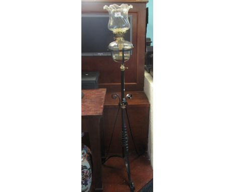 Early 20th century oil burner standard lamp having wrythen design shade and clear glass reservoir standing on a scroll decora