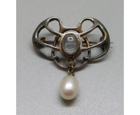 An Art Nouveau white metal brooch, set with moonstone and a pearl drop 