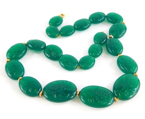 A carved jade necklace, with oval links each engraved with flowers, on yellow metal fine link chain, with dividers, yellow me
