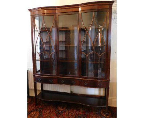 A late Victorian flamed mahogany display cabinet, with satinwood banded double bow front and serpentine cornice, two astragal