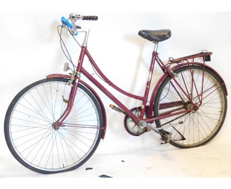 A vintage Raleigh ladies bicycle in purple, with chrome coloured handles and back shelf, 102cm high.