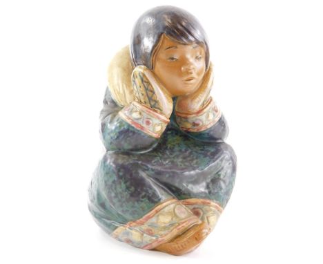 A Lladro ceramic figure of an Eskimo child, with head in hands, in a seated position, printed mark in blue to underside 16cm 