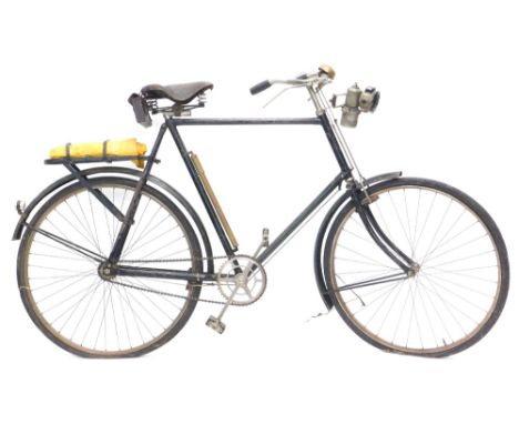 A vintage Raleigh gentleman's bicycle, with black green livery, with a Calcia Club carbide bike lamp.