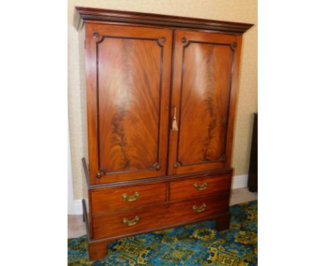 A George III mahogany press cupboard, with dentil moulded cornice over two flame panelled doors, with hanging interior, over 