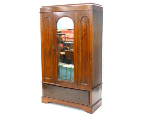 An early 20thC mahogany and satin walnut wardrobe, with a moulded cornice above a single mirrored door, flanked by arched pan