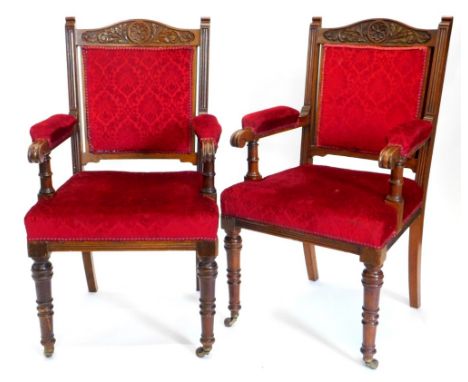 A pair of late 19thC oak open armchairs, each carved with flowers, roundels, etc., with a padded back, arm rest and seat, on 