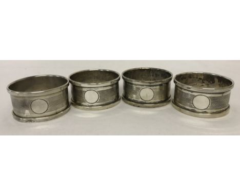 4 matching Art Deco silver serviette rings with engine turned decoration and empty cartouches. Hallmarked Birmingham 1930. Sm