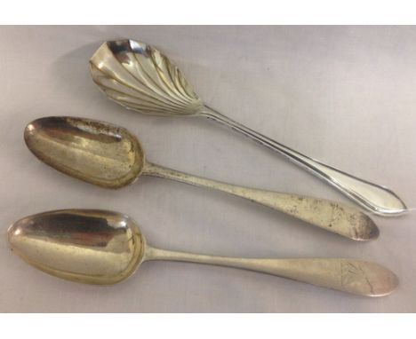 A pair of sterling silver serving spoons with arm and dagger monogram to handles. Together with a serving spoon with scallope