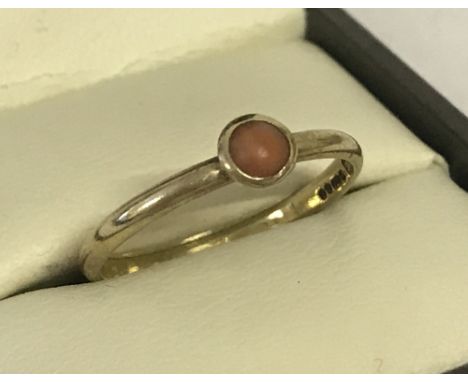 A 9ct gold ladies dress ring, set with a small round coral stone. Coral is bezel set above band. Fully hallmarked to inside o