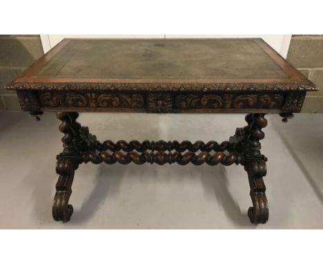 A Victorian 2 drawer, leather topped writing table raised on barley twist legs. With carved detail to drawer fronts and desk 