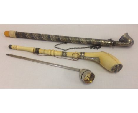 3 long handled pipes. An antique ivory smoking pipe with silver collars and panel to top of bowl. Base of bowl is hinged and 