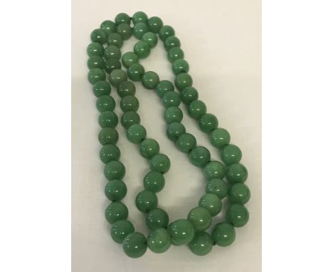A string of green jade beads. Approx. 32 inches long. 