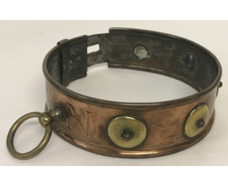 A Victorian copper and brass dog collar. With studded surround and brass disc detail (one disc missing), worn engraved name "